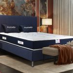 Un matelas avec mousse à mémoire de forme visco aérial avec un sommier et tête de lit en bleu foncé.